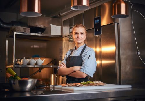 Confident,And,Serious,Female,Chef,Standing,With,Hands,Crossed,In